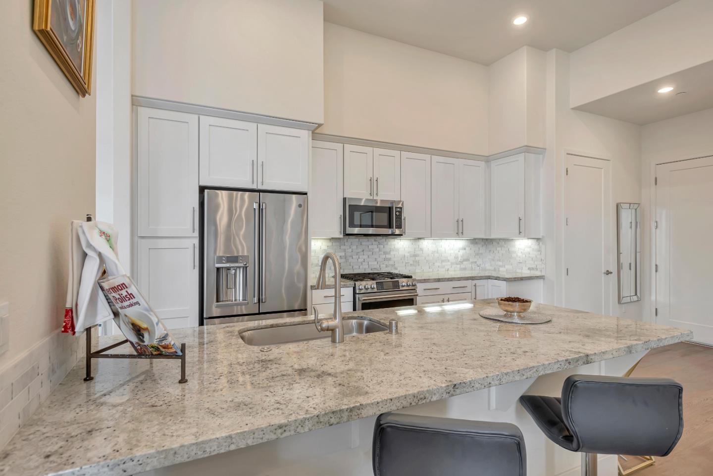 1038 Foster Square Lane, Unit 403 Foster City, CA 94404 - Photo 7 of 28 a kitchen with stainless steel appliances granite countertop a sink refrigerator and cabinets