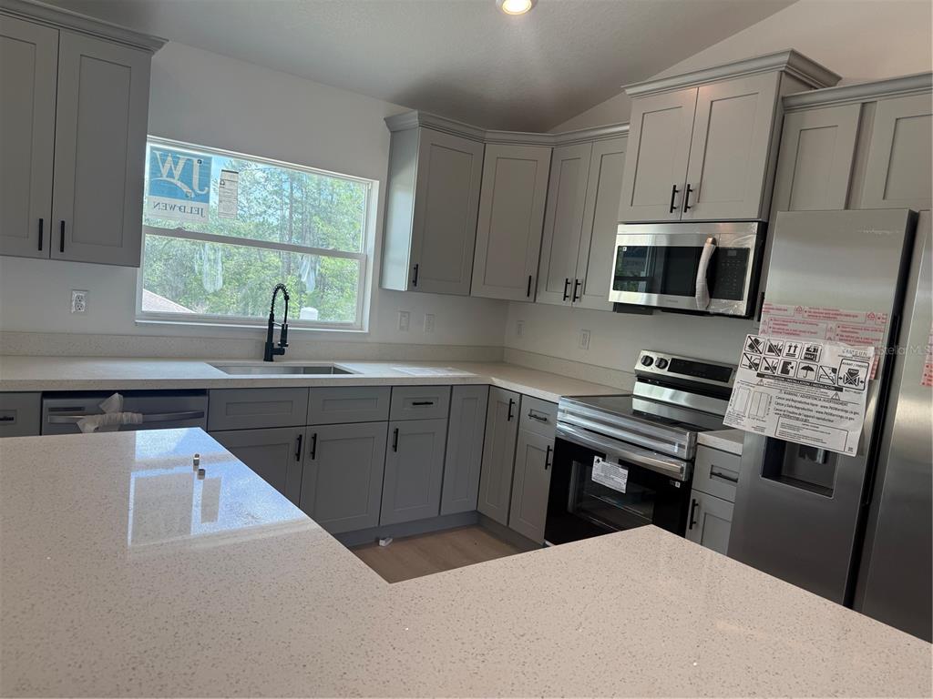 12847 Southwest 84th Terrace Road Ocala, FL 34473 - Photo 6 of 16 a kitchen with cabinets appliances a sink and a window