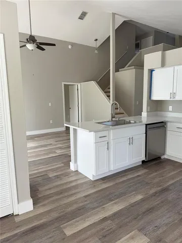 a kitchen with a sink cabinets and wooden floor