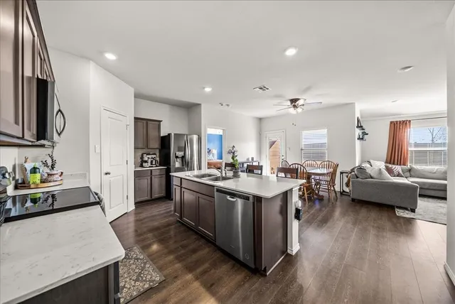 a kitchen with sink stove and refrigerator