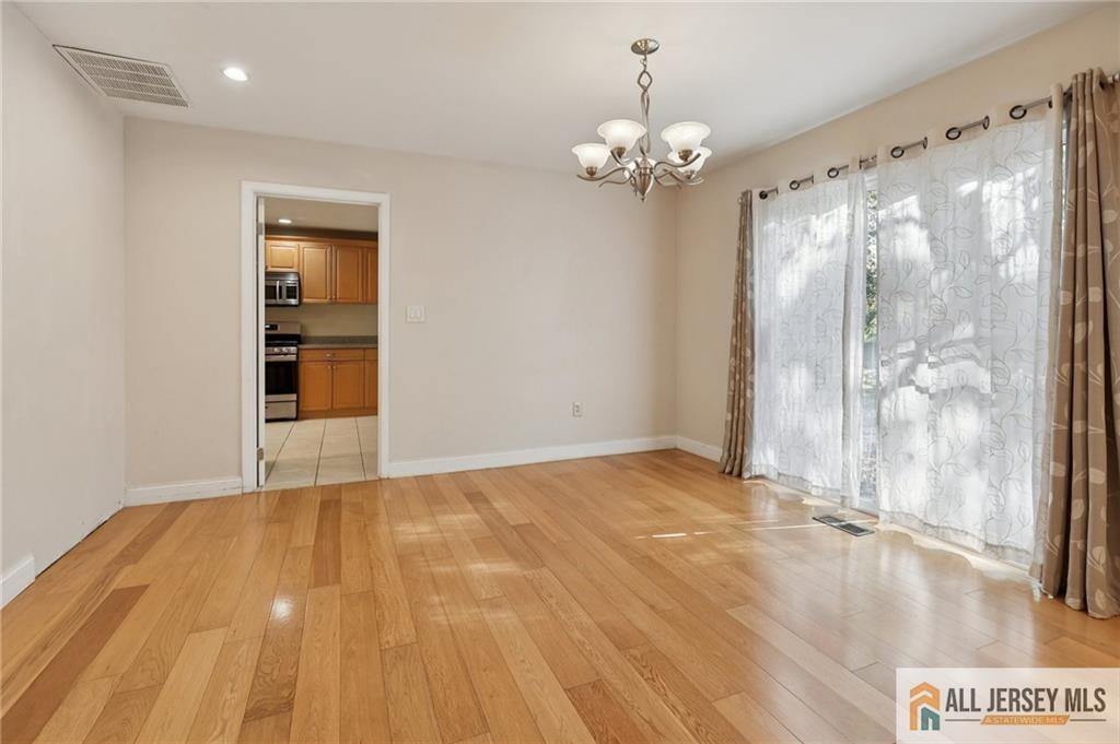 1 Landry Road Somerset, NJ 08873 - Photo 5 of 17 a view of empty room with wooden floor and fan