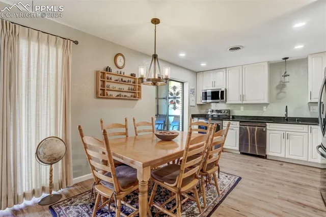 a kitchen with stainless steel appliances kitchen island granite countertop a dining table chairs and granite counter tops