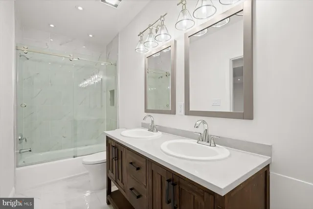 a bathroom with a sink double vanity granite tub and a mirror
