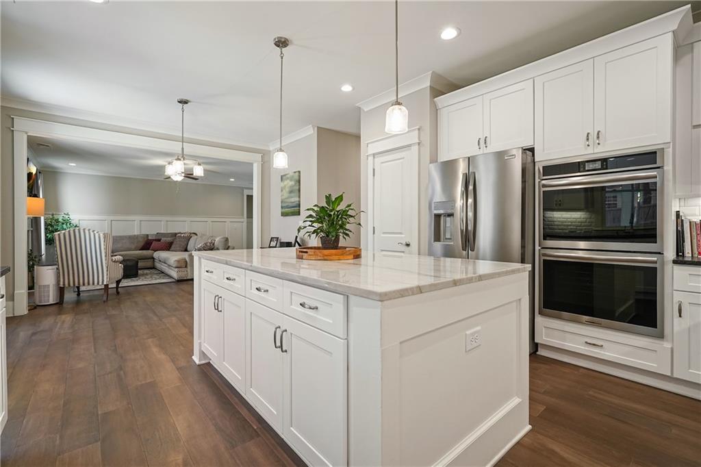 6243 Allen Ivey Road Mableton, GA 30126 - Photo 11 of 46 a kitchen with stainless steel appliances kitchen island granite countertop a stove and a sink