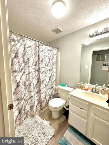 a bathroom with a sink toilet mirror and shower