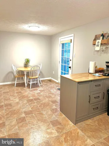 a living room with stainless steel appliances furniture a dining table and a window