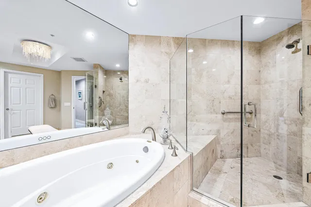 a spacious bedroom with a bed a couch and a large window