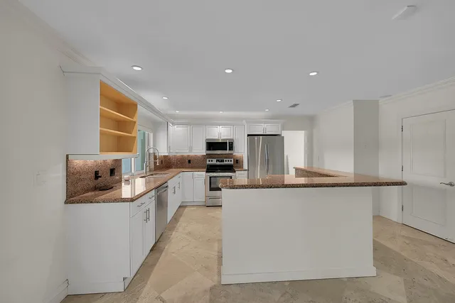 a view of a livingroom with an empty space and a kitchen