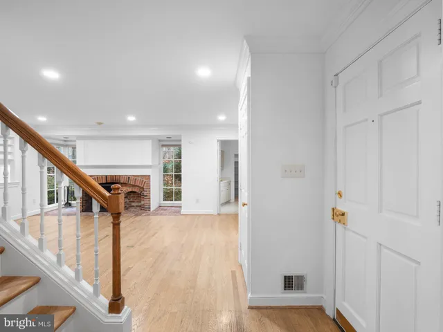 a view of a hallway with wooden floor and staircase