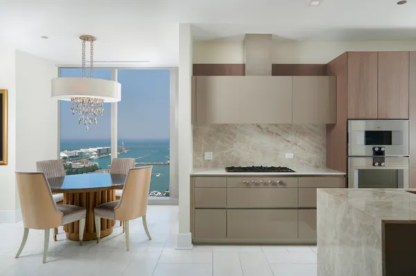 a kitchen with a dining table chairs and a refrigerator