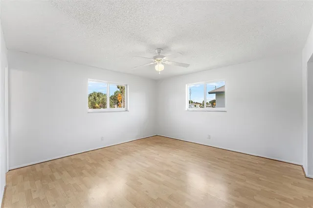 an empty room with a window and a ceiling fan