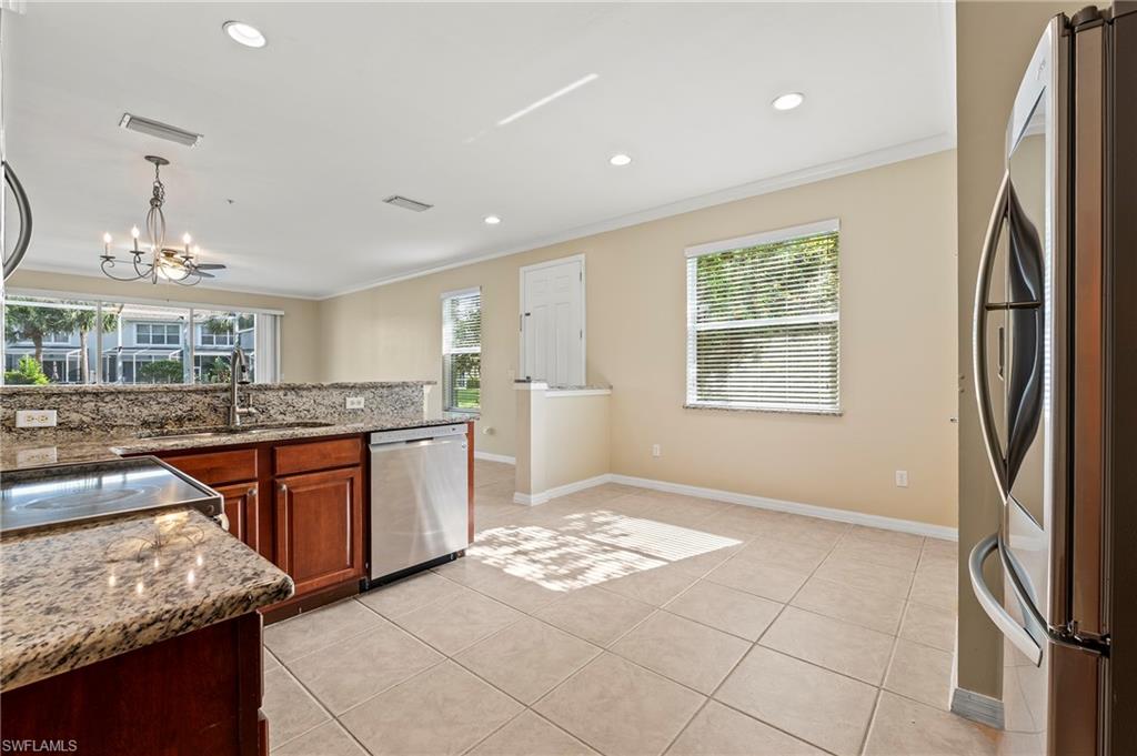 15570 Marcello Circle, Unit 149 Naples, FL 34110 - Photo 11 of 31 a kitchen with stainless steel appliances granite countertop a refrigerator and a sink