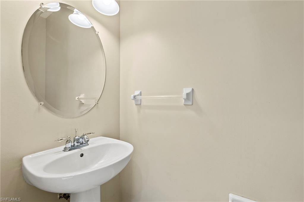 15570 Marcello Circle, Unit 149 Naples, FL 34110 - Photo 15 of 31 a bathroom with a sink and mirror