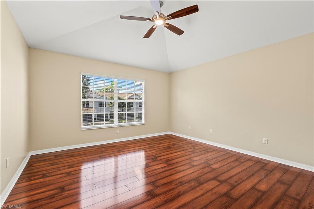15570 Marcello Circle, Unit 149 Naples, FL 34110 - Photo 21 of 31 a view of an empty room with wooden floor and a window