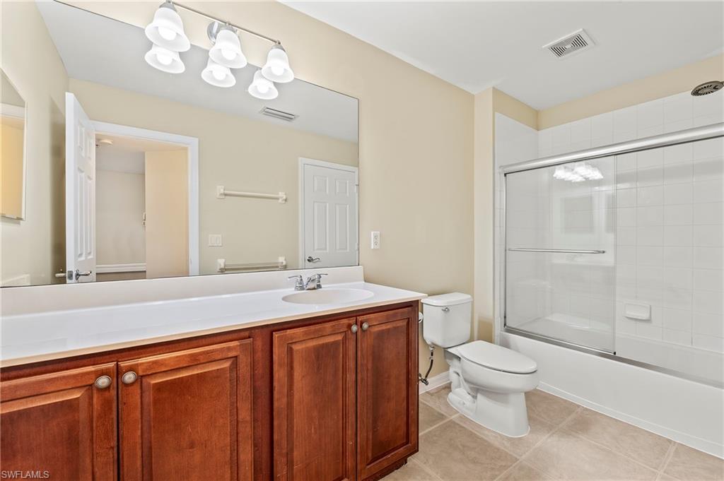 15570 Marcello Circle, Unit 149 Naples, FL 34110 - Photo 23 of 31 a bathroom with a granite countertop sink mirror vanity and toilet