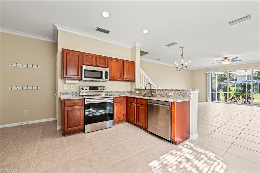 15570 Marcello Circle, Unit 149 Naples, FL 34110 - Photo 10 of 31 a large kitchen with stainless steel appliances granite countertop a stove top oven a sink dishwasher a dining table and chairs