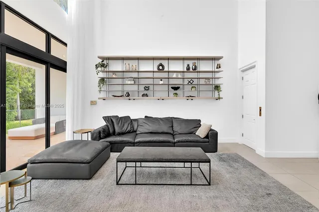 a living room with furniture and a floor to ceiling window