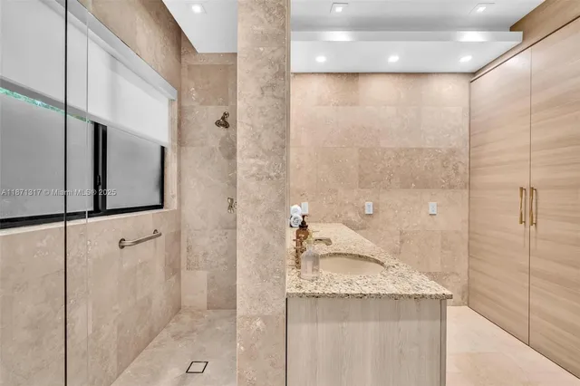 a bathroom with a granite countertop sink a mirror and shower