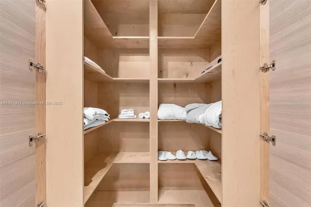 a view of walk in closet with clothes and shoes