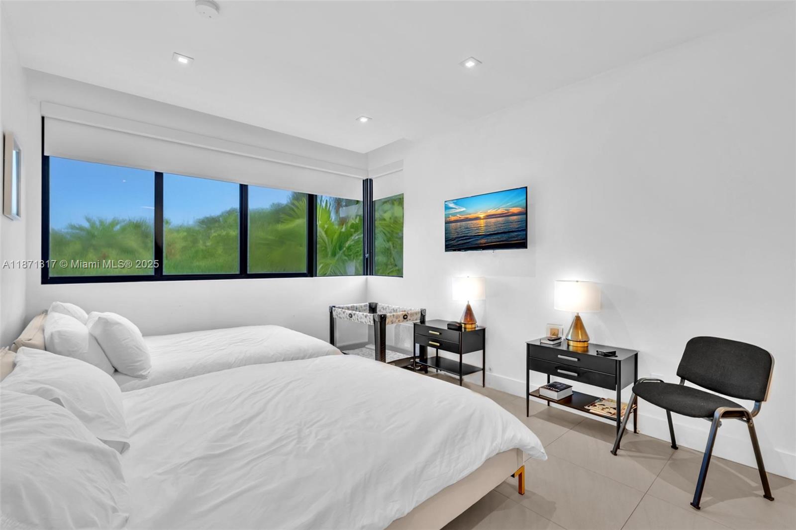 1350 98th Street Bay Harbor Islands, FL 33154 - Photo 24 of 46 a bedroom with a bed a chair and a flat screen tv