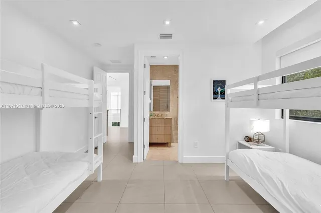 a bedroom with two large bed and a large window