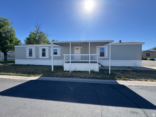 2491 Highway 89, Unit 315 Pleasant View, UT 84404 - Photo 4 of 34 Light blue siding exterior with white trim and a covered front porch featuring white railings