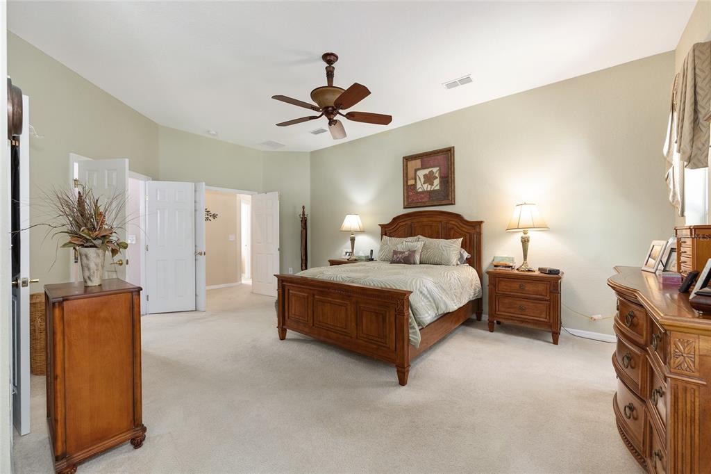 10751 Southwest 71st Circle Ocala, FL 34476 - Photo 13 of 52 a bedroom with a bed and a chandelier