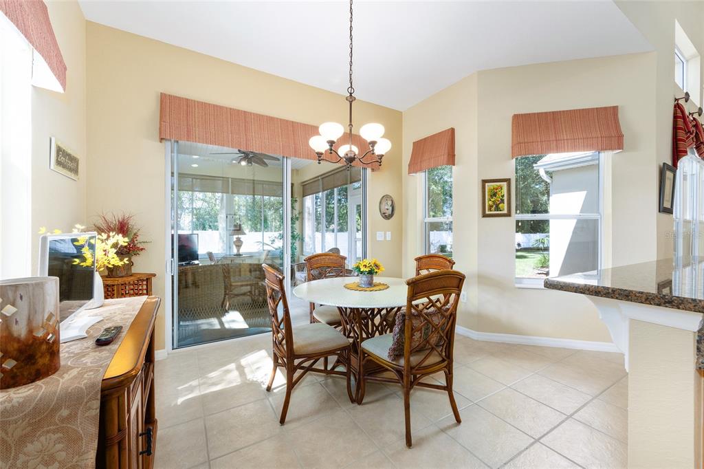 10751 Southwest 71st Circle Ocala, FL 34476 - Photo 28 of 52 a dining room with furniture a chandelier and a large window