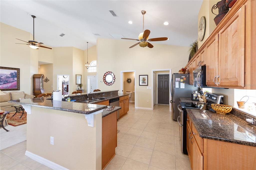 10751 Southwest 71st Circle Ocala, FL 34476 - Photo 32 of 52 a kitchen with kitchen island granite countertop a sink appliances cabinets and furniture
