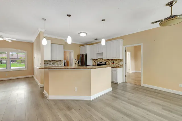 a view of kitchen with refrigerator and wooden floor