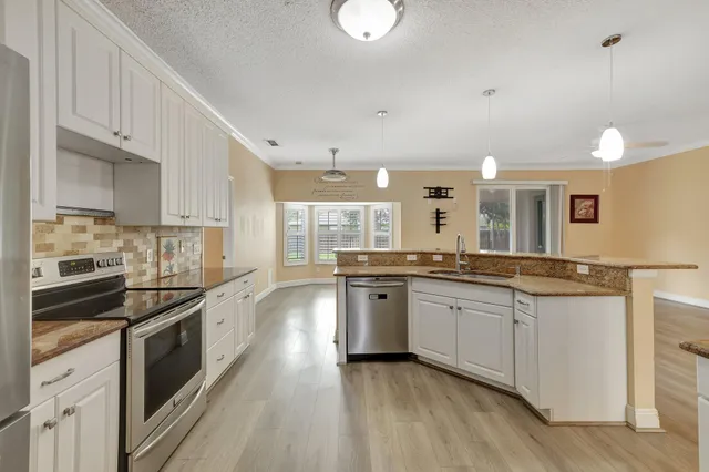 a large kitchen with granite countertop lots of counter space and a sink