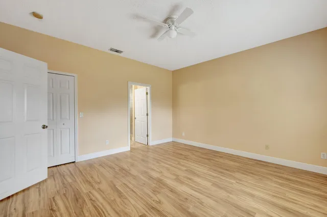 a view of an empty room with wooden floor