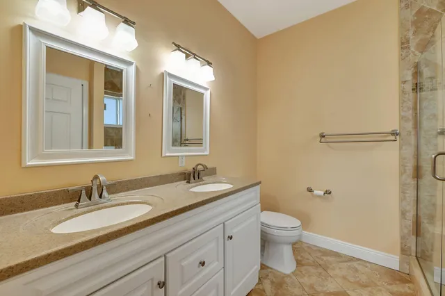 a bathroom with a granite countertop sink toilet and shower