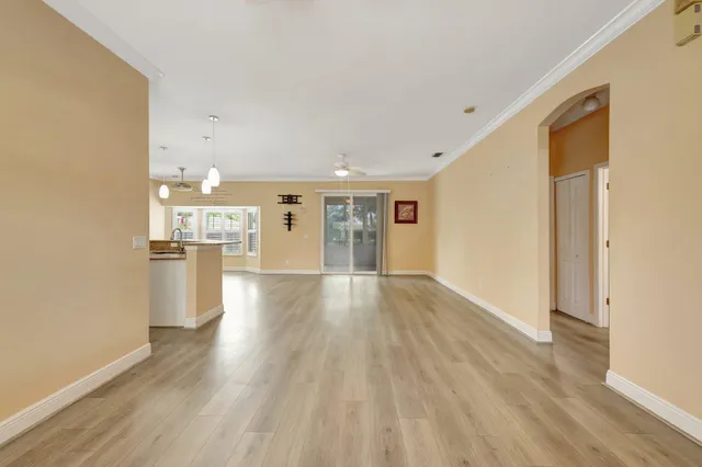 a view of a kitchen with a fridge and wooden floor