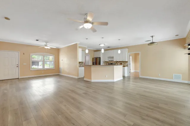 a view of a kitchen with a kitchen island wooden floor and a window