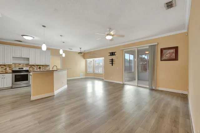 a view of kitchen with refrigerator and wooden floor