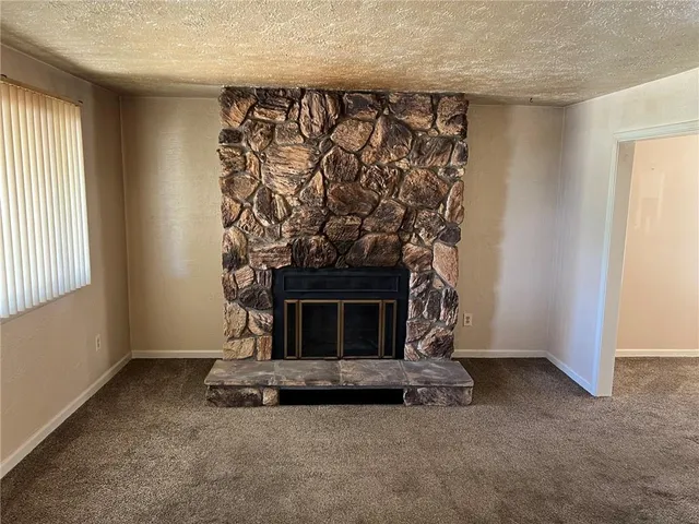 an empty room with a fireplace and window