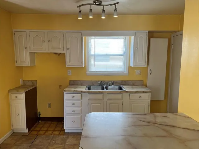 a spacious bathroom with a granite countertop sink a mirror and a bathtub