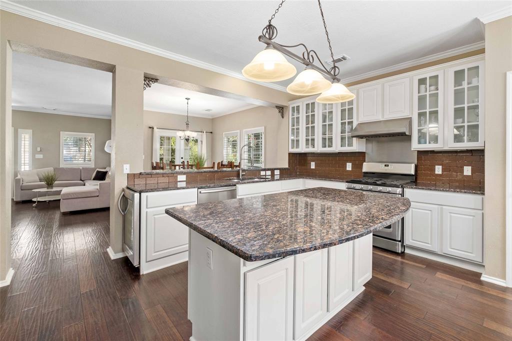2730 Kinney Oaks Court Austin, TX 78704 - Photo 9 of 32 Beautifully designed kitchen featuring rich hardwood floors and an expansive granite island, perfect for everyday living and entertaining.