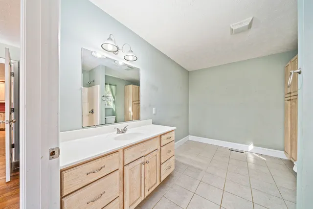 a spacious bathroom with a double vanity sink and a mirror