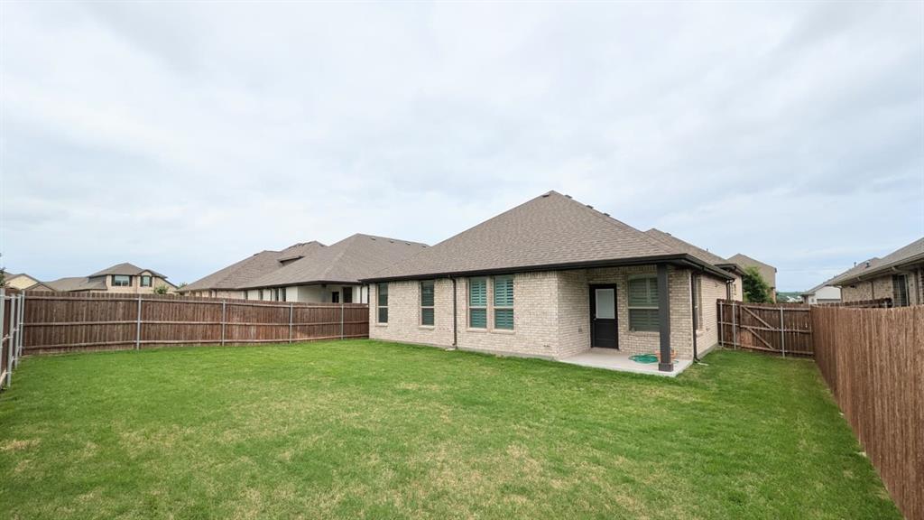 1140 Knightsbridge Road Argyle, TX 76226 - Photo 11 of 13 The property features a spacious backyard with a well-maintained lawn and a private wooden fence