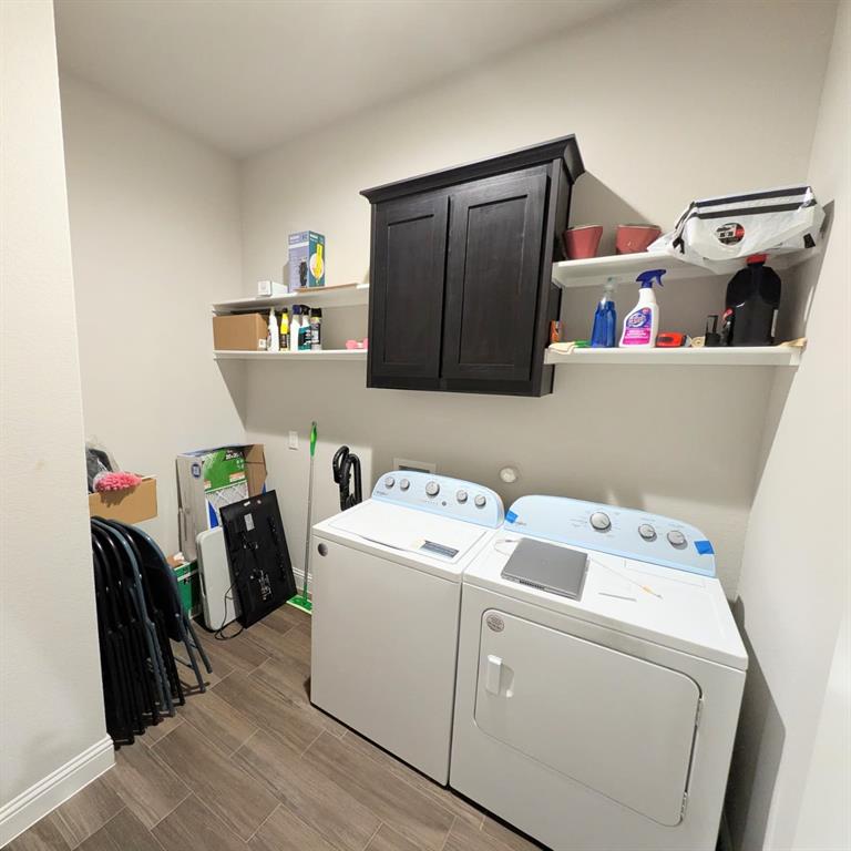 1140 Knightsbridge Road Argyle, TX 76226 - Photo 10 of 13 This utility room features wood-look tile flooring, white walls, and a dark wood cabinet mounted above shelving