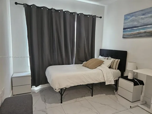 a bed sitting in a bedroom next to a cabinet