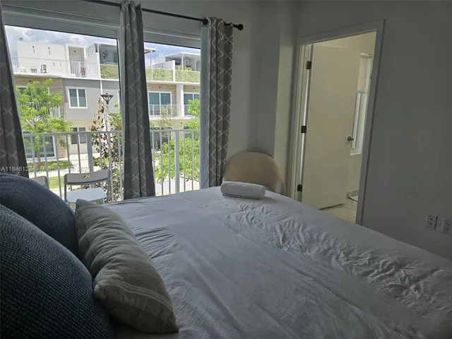 a bedroom with a bed and a large window