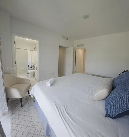 a spacious bedroom with a bed and a couch