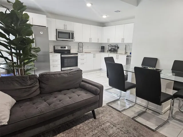 a living room with furniture and kitchen view