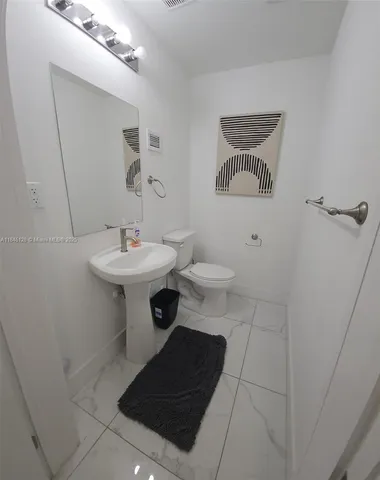 a bathroom with a sink toilet and a mirror