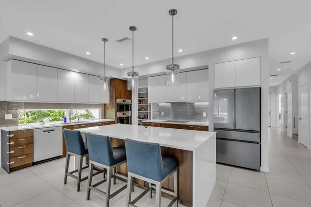 a living room with furniture kitchen view and a large window