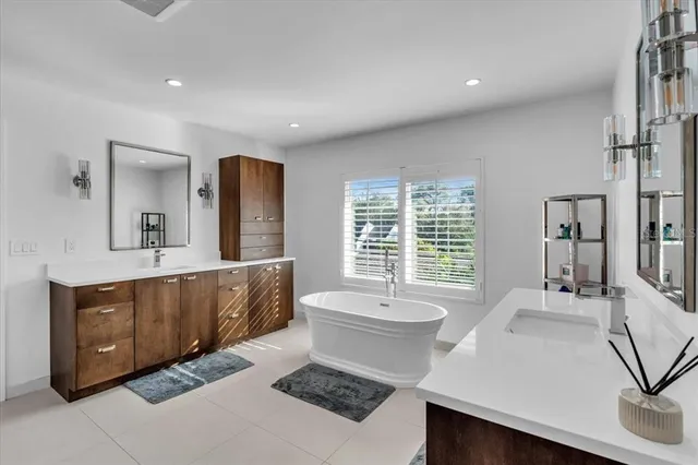 a spacious bathroom with a shower a sink and a mirror