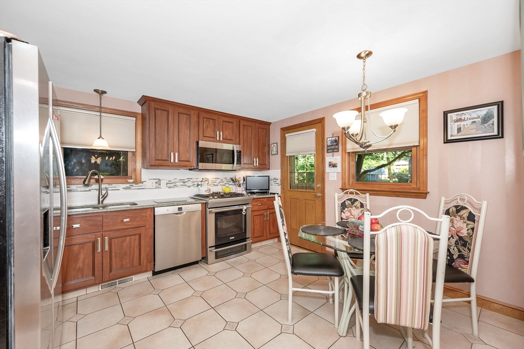 73 Partridge Road Billerica, MA 01821 - Photo 9 of 37 a kitchen with granite countertop stainless steel appliances a stove top oven a sink a dining table and chairs